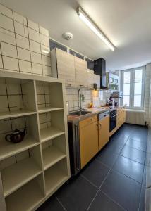 a kitchen with yellow shelves and a sink in a room at maison des chanoines in Toul
