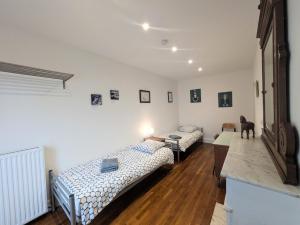 a room with two beds and a table in it at maison des chanoines in Toul