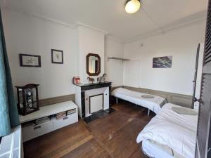 a bedroom with two beds and a desk and a mirror at maison des chanoines in Toul