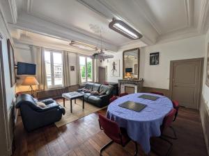 a large living room with a table and a couch at maison des chanoines in Toul