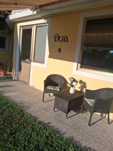 two chairs and a table in front of a building at Apartma DUA in Strunjan