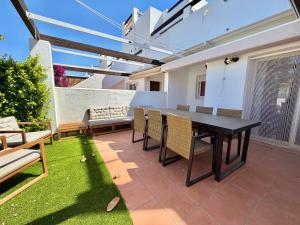 a patio with a black table and chairs and grass at Condado de Alhama 5 SV29 in Alhama de Murcia
