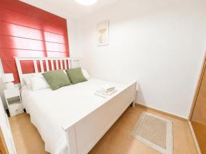 a bedroom with a white bed with a red wall at Condado de Alhama 5 SV29 in Alhama de Murcia