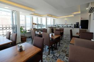 a restaurant with wooden tables and chairs and windows at Pera Arya Hotel in Istanbul