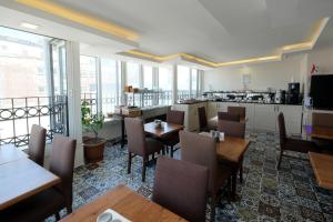 a restaurant with tables and chairs and a kitchen at Pera Arya Hotel in Istanbul