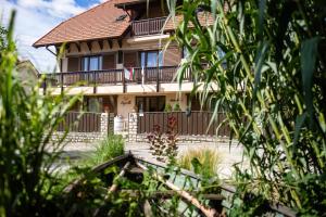 a house with a porch and a balcony at Fürjes Villa Panzió in Balatonfüred