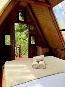 a bedroom with a bed with two rolled towels at Treehouses Yao Noi in Ko Yao Noi