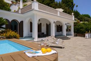 Villa Capri by MyVillaCollection في كابري: منزل به مسبح وطاولة عليها فاكهة