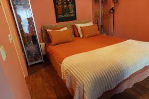 a bedroom with a bed with an orange and white comforter at Exceptional B&B in Reeuwijk