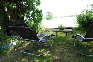 two chairs and a table in front of a lake at Exceptional B&B in Reeuwijk