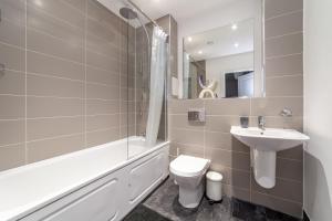 a bathroom with a sink and a toilet and a bath tub at Gorgeous 1 Bed Apartment in Poplar in Richmond upon Thames