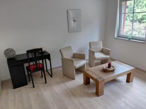 a living room with two chairs and a table and a piano at Alte Mühle in Holzminden