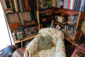 a chair in front of a book shelf with books at Exceptional B&B in Reeuwijk