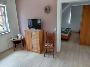 a living room with a tv and a dresser with a tvicterictericter at Alte Mühle in Holzminden