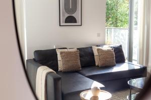 a black couch in a living room with a window at Gorgeous 1 Bed Apartment in Poplar in Richmond upon Thames +20 photos