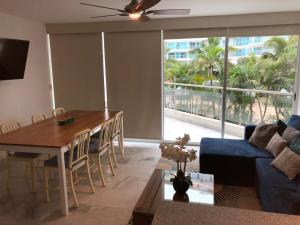 a living room with a table and a blue couch at Aria Ocean Rentals - Riviera Nayarit in Nuevo Vallarta