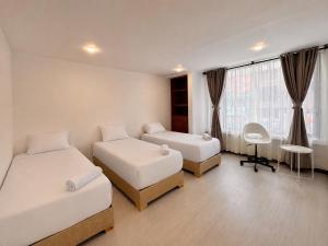 a hotel room with two beds and a window at Zentio Hotel in Bogotá