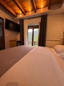 a large bed in a room with a window at Gegest Hotel in Theth