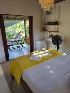 a bedroom with a bed with a yellow blanket at Green Coconut - Icaraí Kite Village in Icaraí