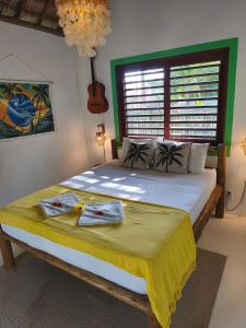 a bedroom with a bed with two towels on it at Green Coconut - Icaraí Kite Village in Icaraí +6 photos