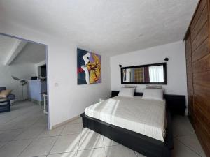 a bedroom with a bed in a white room at Chez Antoinette et Jo in Drap +11 photos