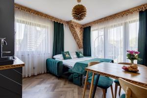 a hotel room with a bed and a table and a kitchen at Tatra Forest Apartments in Zakopane