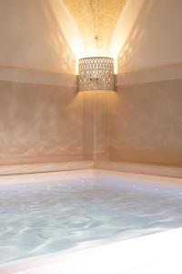 a bath tub with a chandelier in a room at Residenza Kalù in Grottaglie