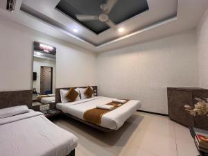 a bedroom with two beds in a room at New Vyankatesh in Mahabaleshwar