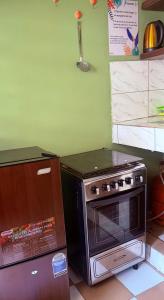 a kitchen with a stove and a refrigerator at Studio Paisible Aéroport FHB in Abidjan +2 photos