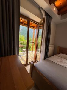 a bedroom with a bed and a view of a balcony at Gegest Hotel in Theth