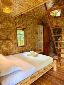 a bedroom with a large bed in a log cabin at Treehouses Yao Noi in Ko Yao Noi