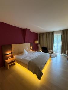 a bedroom with a large bed in a purple wall at Hotel Krainerhütte in Baden +46 photos