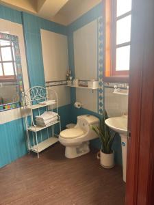 a bathroom with a toilet and a sink at The House in Tacna +138 photos