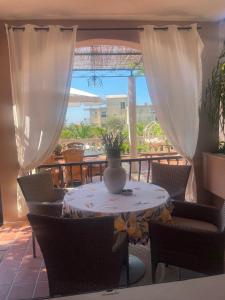 a table and chairs with a vase on a patio at Villa Bougenvilia Tomas in Tučepi