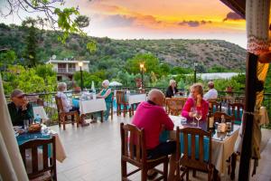 a group of people sitting at tables on a patio at Flower Hotel Patara in Patara