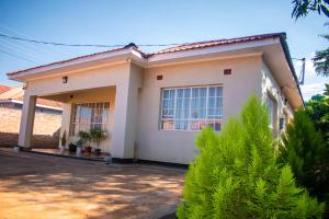 a small white house with a driveway at The Cottage in Lilongwe