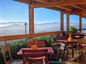 a restaurant with tables and chairs and a view of mountains at Erta Terra Hotel in Mazzolla