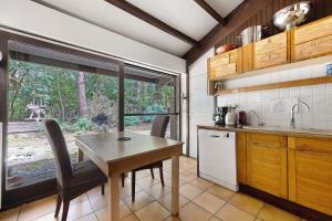 a kitchen with a table and chairs and a window at Maison de vacances Namasté in Mérignac