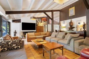a living room with a couch and a tv at Maison de vacances Namasté in Mérignac