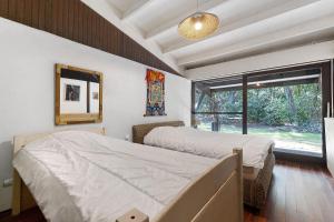 a bedroom with two beds and a large window at Maison de vacances Namasté in Mérignac +28 photos
