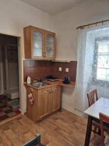 a kitchen with wooden cabinets and a sink and a table at Penzion Many Peny in Jindřichŭv Hradec