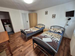 a room with two beds and a table and chairs at Penzion Many Peny in Jindřichŭv Hradec