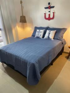 a bedroom with a blue bed with pillows at Sumar your beach house in Japaratinga in Japaratinga