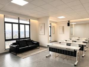 a room with a black couch and tables and windows at Greenland Apartment by Link in Kigali