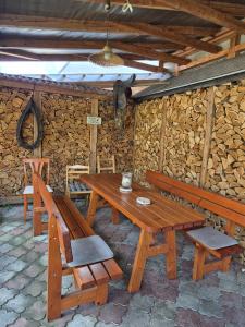 a wooden table and chairs and a bench and a wall at Penzion Many Peny in Jindřichŭv Hradec
