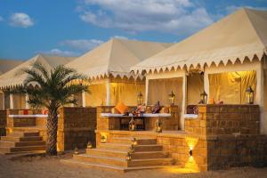 a tent with a palm tree in front of it at Best desert camp in jaisalmer The Velvet Dunes in Sām