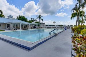 a swimming pool at a resort with palm trees at Pool + Dock Access! Boater’s Base in Lake Placid in Lake Placid