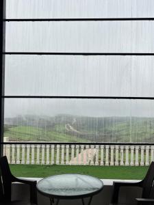 a table and chairs in front of a large window at إستراحة حجيف فيو in Salalah