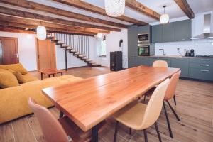 a kitchen and a dining room with a wooden table and chairs at Kuća za odmor Čevo in Podevčevo