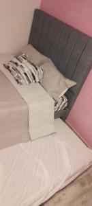 a white bed with a black headboard and pillows at Apartamento C&B in Bello